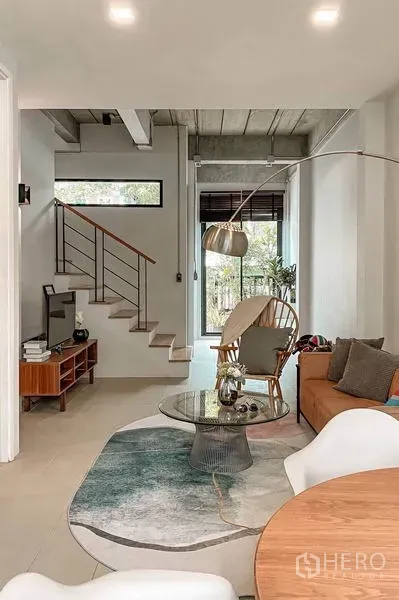 ทาวน์เฮาส์ ให้เช่าในHuai Khwang, Bangkok - โถงนั่งเล่นเปิดโล่งพร้อมชั้นวางทีวี บันได และประตูกระจกสูงออกสู่ชานบ้าน