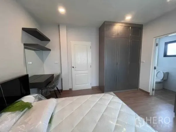 Detached House for rent in Don Mueang, Bangkok - Bedroom corner with built-in wardrobe, vanity desk and door to an ensuite bathroom.