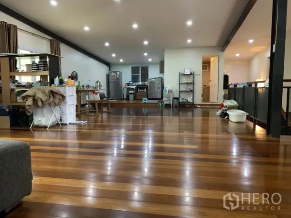 Home Office for rent in Lam Luk Ka, Pathum Thani - Open-plan living area with polished wooden floors and recessed lighting.