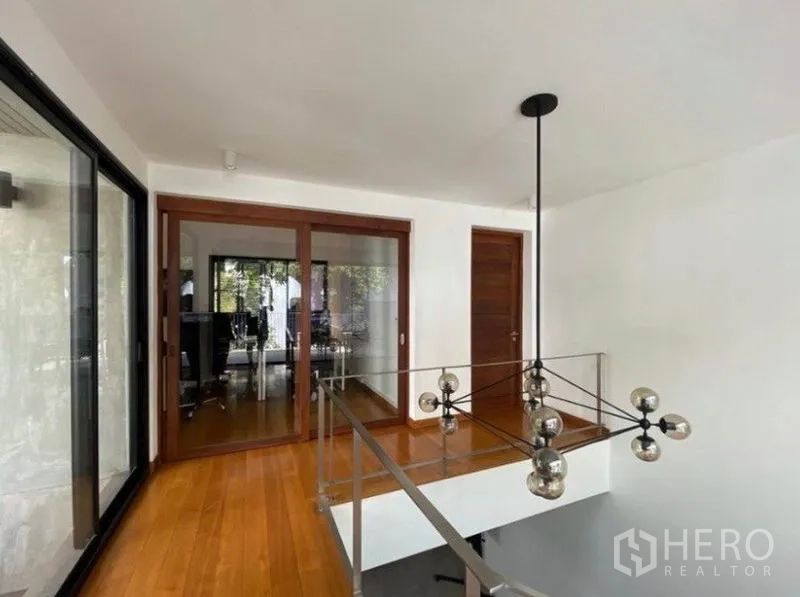 ทาวน์เฮาส์ ให้เช่าในKhlong Toei, Bangkok - โถงชั้นบนพร้อมราวกระจก โคมไฟห้อย และประตูเลื่อนไม้