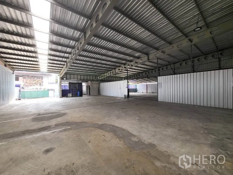 Warehouse for rent in Din Daeng, Bangkok - Large storage hall featuring long‑span trusses, skylight roof panels and drive‑in access.