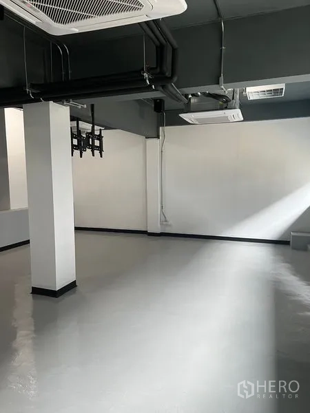 零售空间 出租在Watthana, Bangkok - 空置店铺明亮角落，环氧地坪与外露管线。