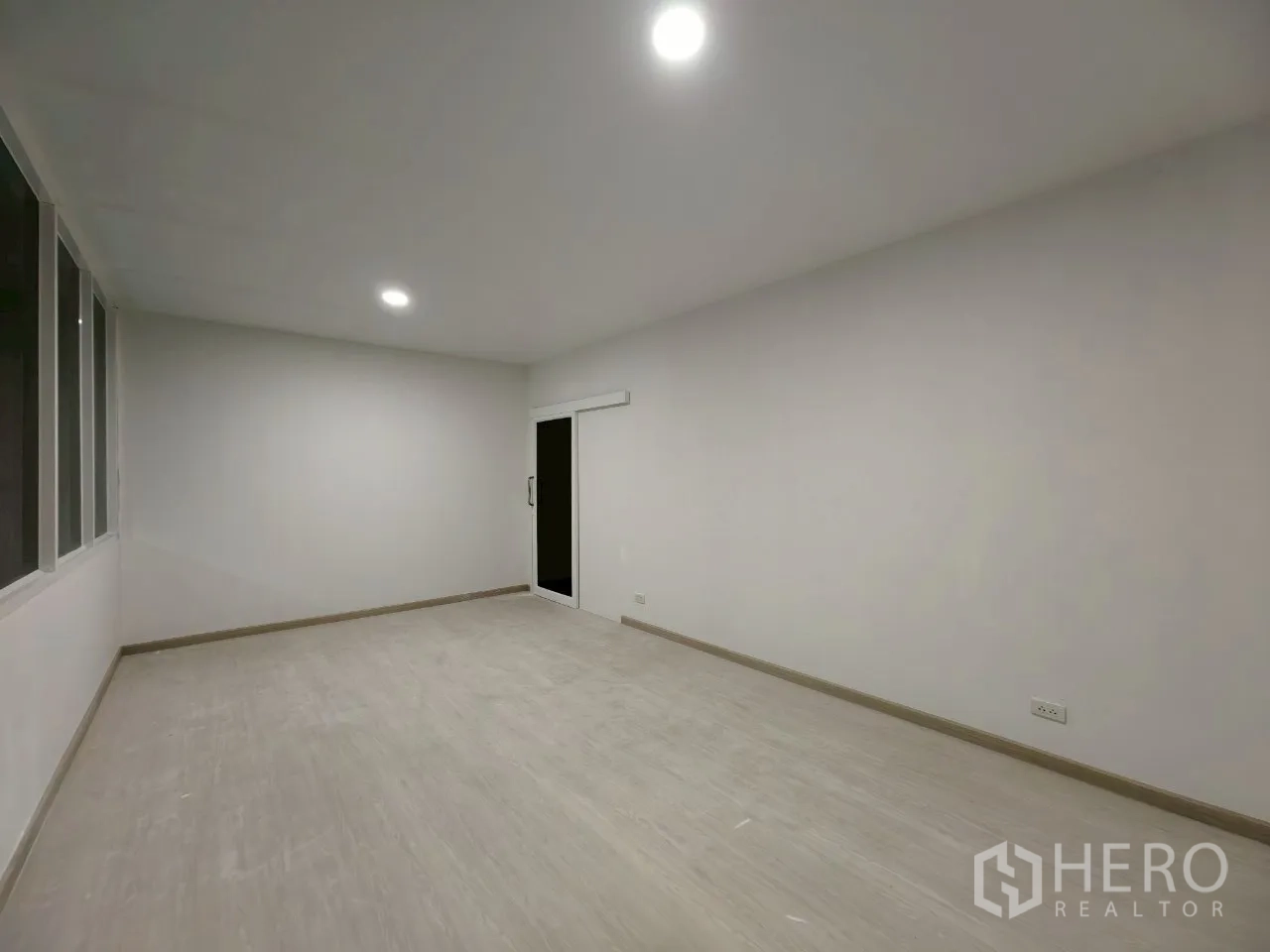 Warehouse for rent in Phra Khanong, Bangkok - Bright finished office room with ceiling lights and a sliding glass door.