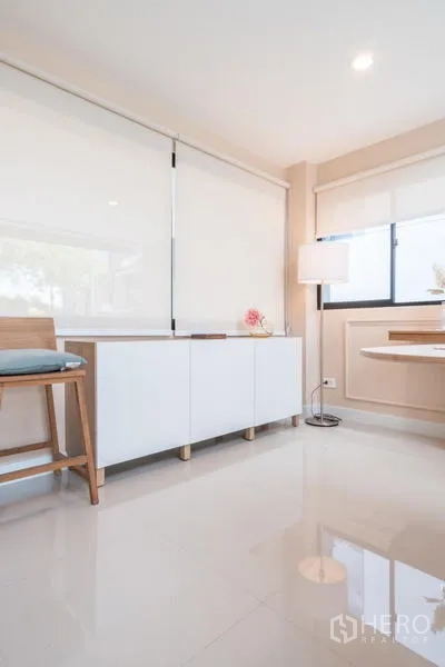 ทาวน์เฮาส์ ให้เช่าหรือขายในSuan Luang, Bangkok - มุมห้องทานข้าวพร้อมตู้วางของสีขาว โคมไฟตั้งพื้น และพื้นกระเบื้องเงา