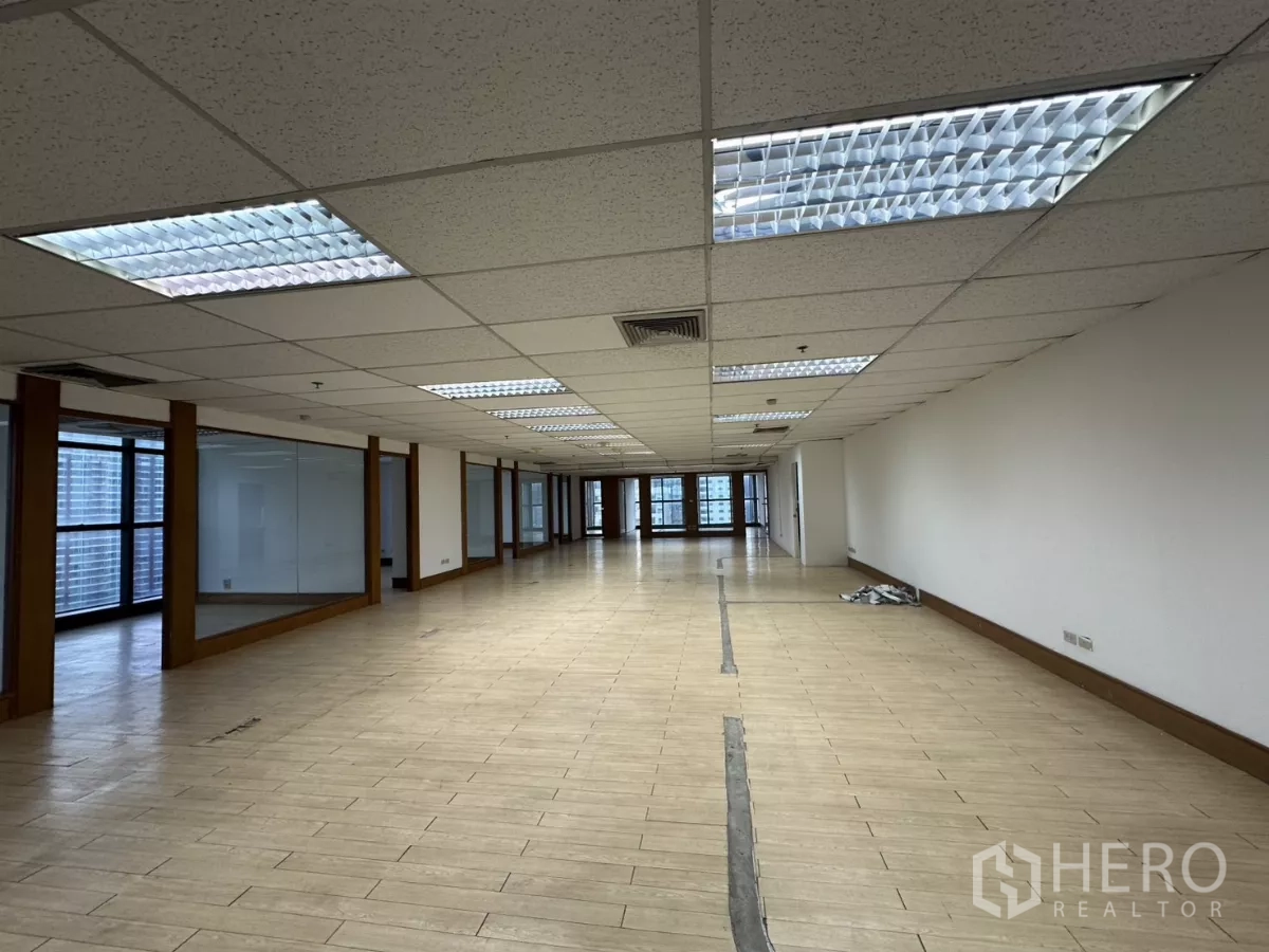 Office Space for rent in Watthana, Bangkok - Expansive open office floor with suspended fluorescent lighting and wood-look tiles.