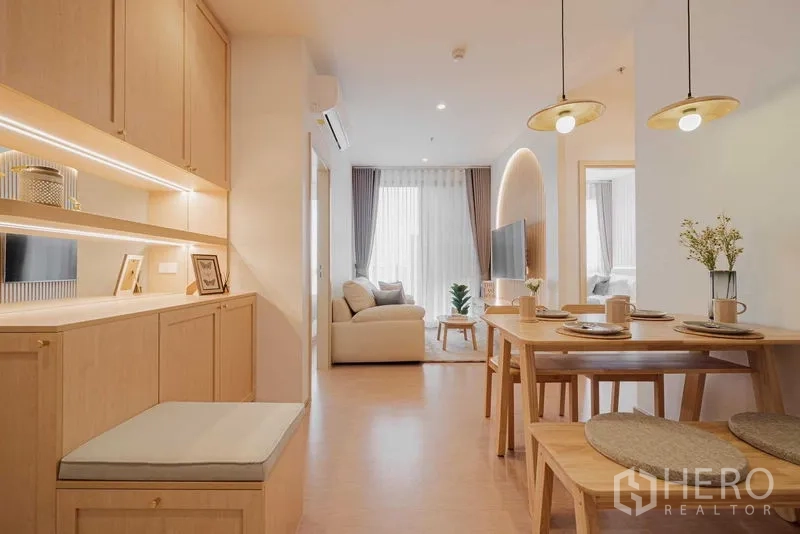 Condominium for rent in Watthana, Bangkok - Hallway view to the living room, showcasing built-in storage and dining set.