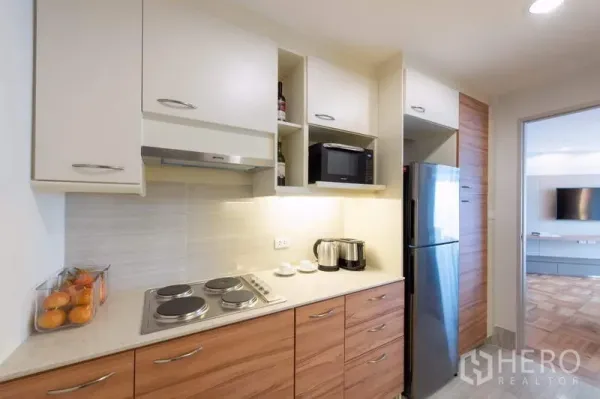 Apartment for rent - Modern kitchen with electric cooktop, range hood, microwave, ample cabinetry and stainless refrigerator.