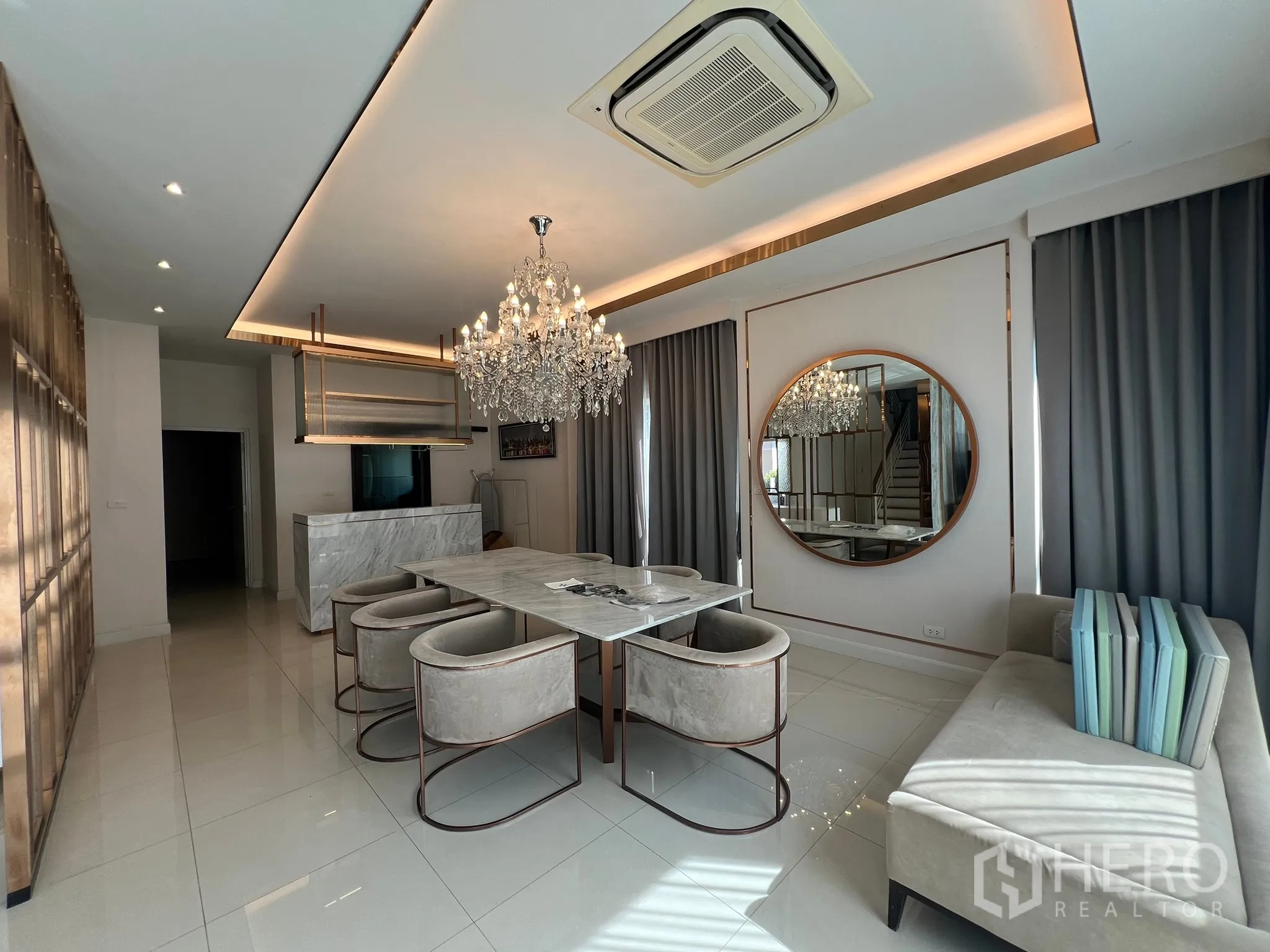 บ้าน ให้เช่าหรือขายในPrawet, Bangkok - มุมห้องทานอาหารพร้อมโคมคริสตัล ไอส์แลนด์หินอ่อน และผ้าม่านสีเทา