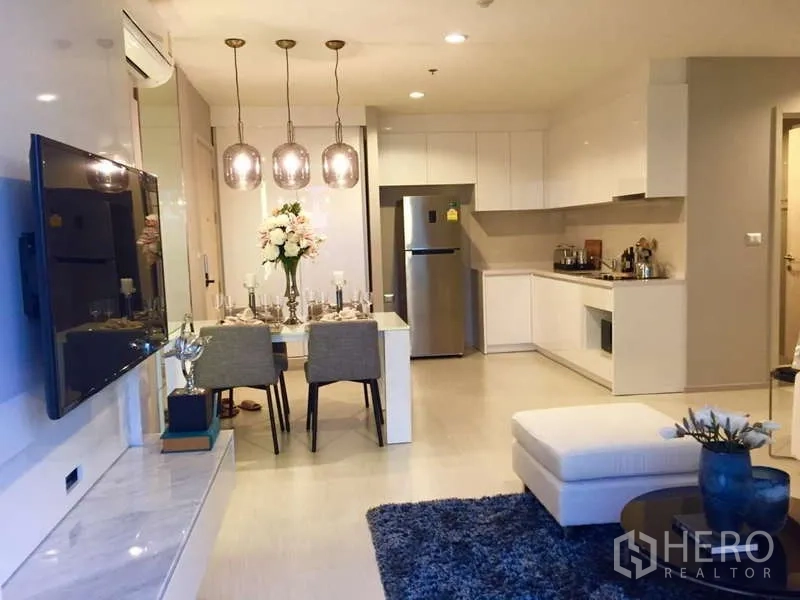 คอนโด ให้เช่าในKhlong Toei, Bangkok - พื้นที่นั่งเล่นรับประทานอาหารและครัวสีขาวแบบโอเพ่น พร้อมตู้สูงและตู้เย็น