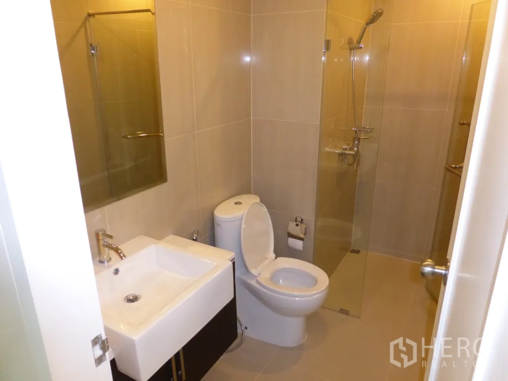 คอนโด ให้เช่าหรือขายในRatchathewi, Bangkok - ห้องน้ำสมัยใหม่พร้อมอ่างล้างหน้า โถสุขภัณฑ์ และฝักบัวแบบกระจกกั้น