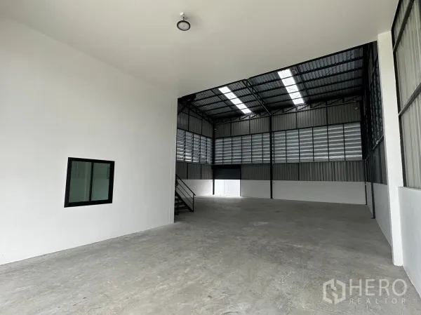 Warehouse for rent or sale - Interior bay with skylights, ventilated louver panels and smooth floor.