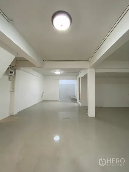 Detached House for rent in Bang Na, Bangkok - Deep open room with polished tile flooring and ceiling lights leading to the rear section of the house.