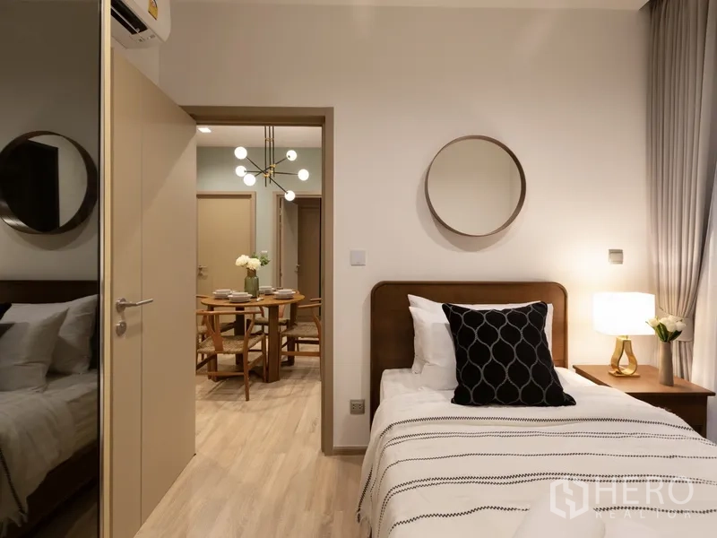 คอนโด ให้เช่าหรือขายในWatthana, Bangkok - ห้องนอนที่สองเตียงเดี่ยวพร้อมโคมไฟหัวเตียง มองเห็นโซนรับประทานอาหาร