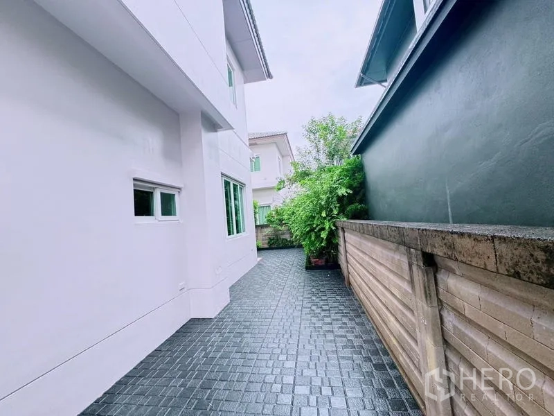 Detached House for rent in Prawet, Bangkok - Rear side walkway along the boundary wall and house exterior.