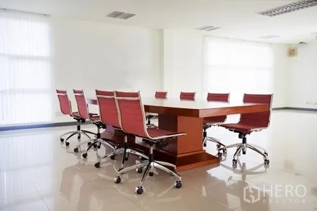 Factory for rent in Chachoengsao - Conference room with a wooden meeting table and red swivel chairs.