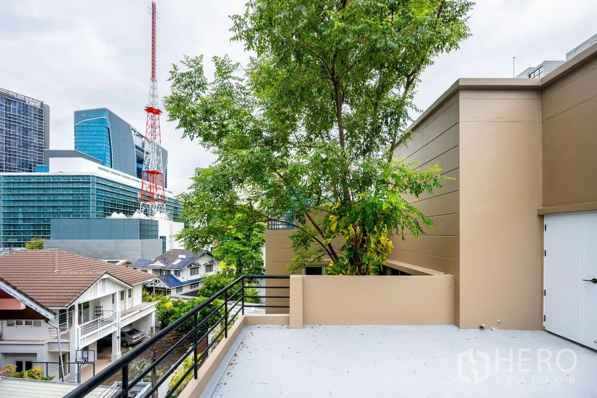 Detached House for rent or sale in Chatuchak, Bangkok - Rooftop terrace with tree planter and city building views.