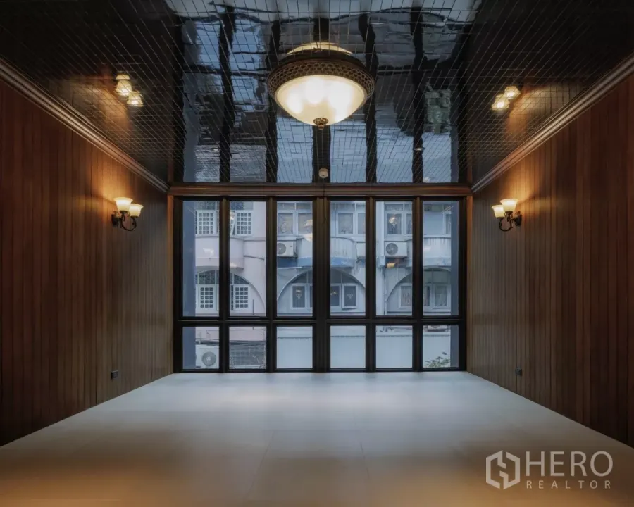 Office Space for rent in Bang Rak, Bangkok - Empty studio‑style room with glossy black ceiling and a wide window wall