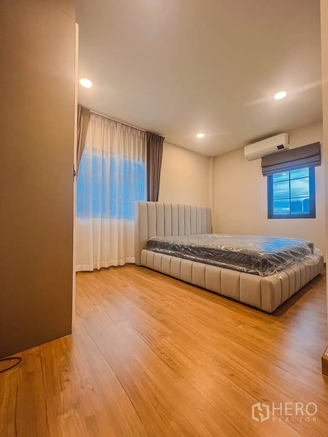 独栋房屋 for rent in Bang Phli, Samut Prakan - 卧室采光充足，设软包床、木地板、窗帘与壁挂空调。