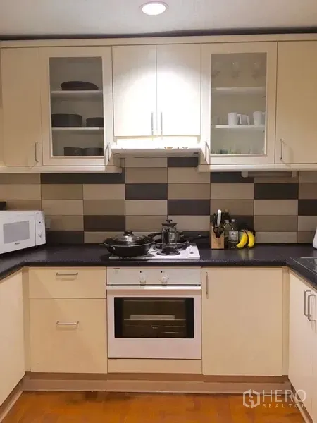 คอนโด ให้เช่าในPathum Wan, Bangkok - ห้องครัวรูปตัว U ตู้สีขาว กระเบื้องผนังลายโมเสก เตาอบ ไมโครเวฟ และพื้นที่เก็บของครบ