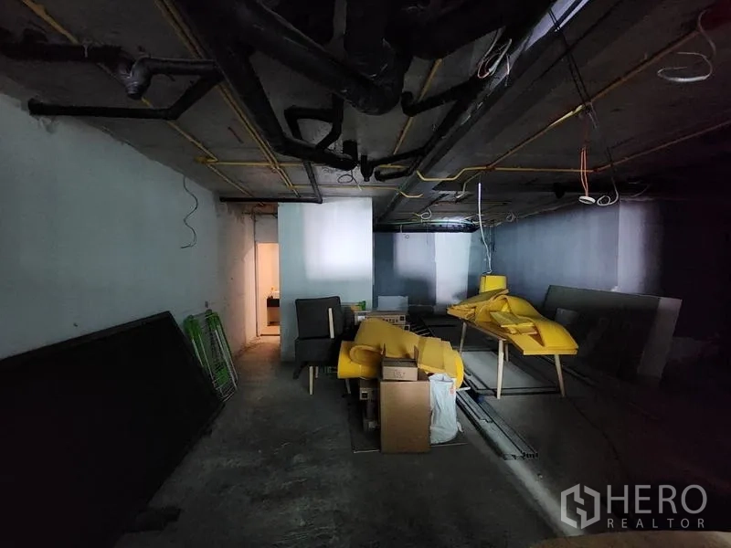 Retail Space for rent - Unfinished interior space with exposed ceiling pipes and a back room ready for fit-out.