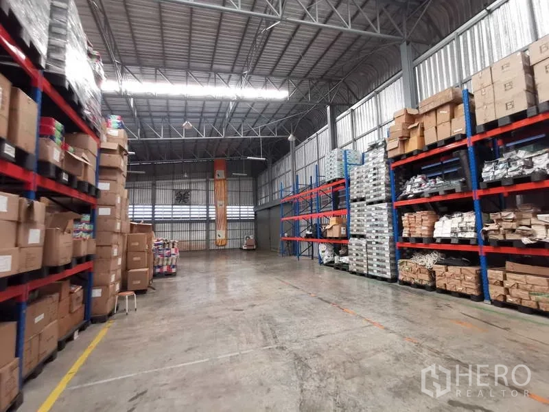คลังสินค้า ให้เช่าหรือขายในNonthaburi - ทางเดินโกดังเพดานสูงพร้อมชั้นวางพาเลทและพื้นคอนกรีตสำหรับรถโฟร์คลิฟท์