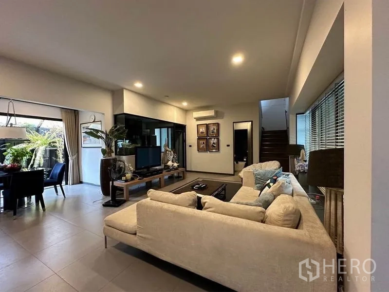 Townhouse for rent or sale in Bang Phli, Samut Prakan - Living area facing TV corner, staircase and air-conditioning next to wide windows.