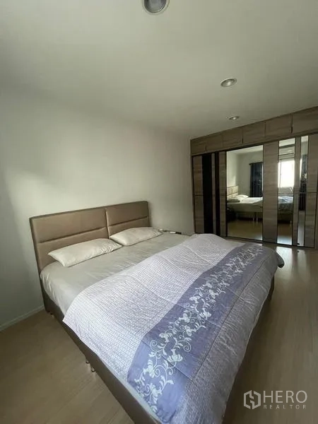 ทาวน์เฮาส์ ให้เช่าในSuan Luang, Bangkok - ห้องนอนพร้อมเตียงบุผ้าและตู้เสื้อผ้าบานกระจก พื้นไม้