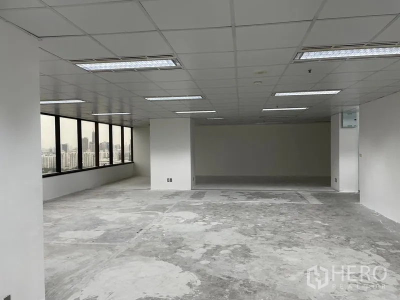 办公空间 出租在Din Daeng, Bangkok - 深进深楼层，结构立柱与临街窗带，面向城市景观。