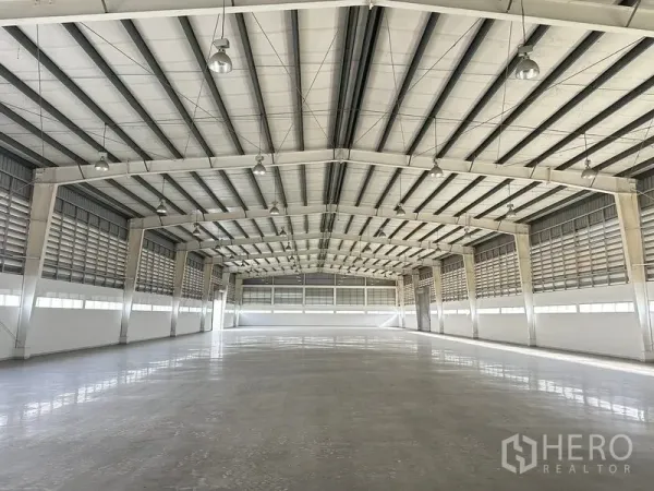 工厂 出租在Phra Nakhon Si Ayutthaya - 宽敞仓库内部，高钢结构屋架，抛光地坪与百叶通风墙。