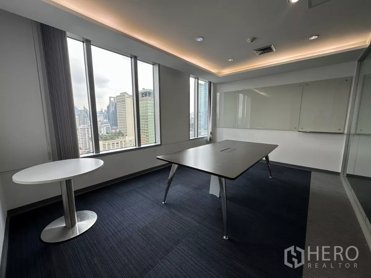 Office Space for rent in Watthana, Bangkok - Compact meeting room with a round side table, city view through tall windows and ceiling cove lights.