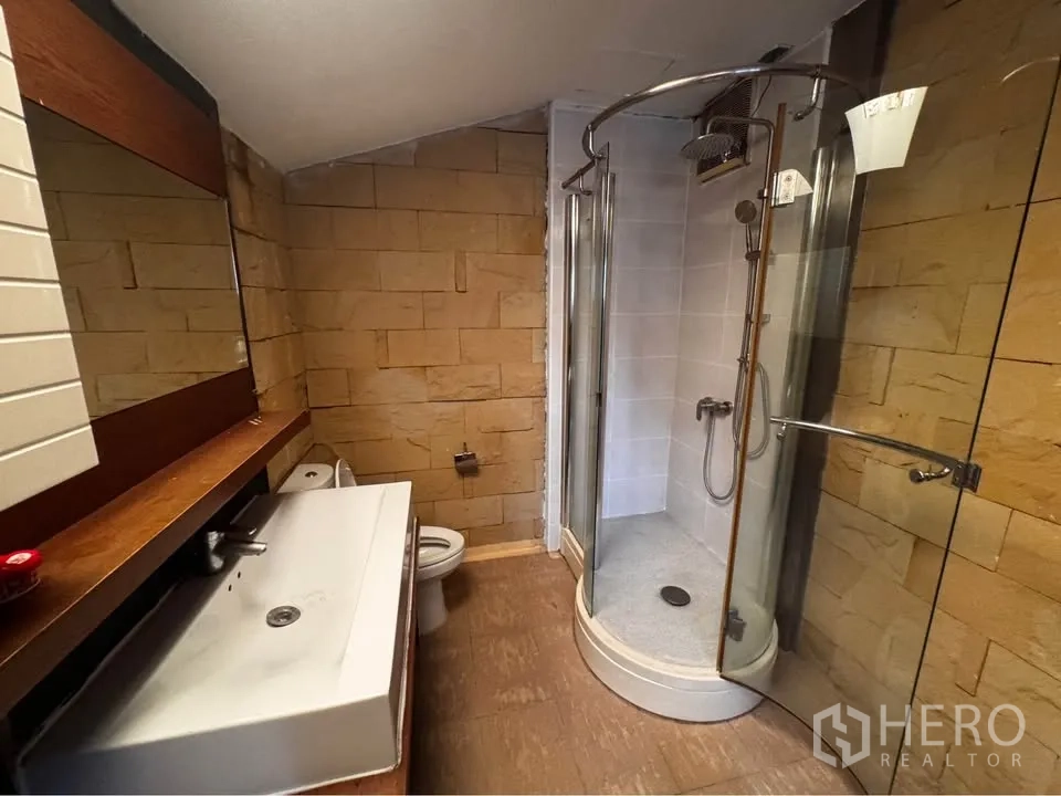 ทาวน์เฮาส์ for rent in Huai Khwang, Bangkok - ห้องน้ำพร้อมตู้กระจกอาบน้ำ มุมอ่างล้างหน้า และผนังกระเบื้องลายหิน.