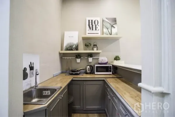 ทาวน์เฮาส์ ให้เช่าในKhlong Toei, Bangkok - ครัวรูปตัว U ท็อปไม้ ตู้สีเทา อ่างล้างจาน และชั้นลอยพร้อมเครื่องใช้ไฟฟ้า