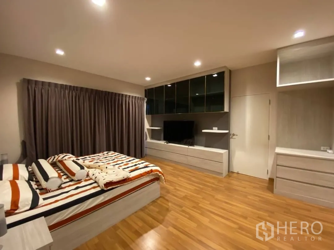 独立式住宅 出租或出售在Prawet, Bangkok - 主卧另一角，木地板与定制电视柜和收纳。