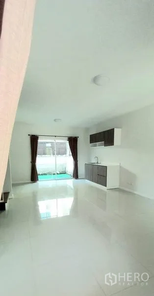 ทาวน์เฮาส์ ขายในMueang Pathum Thani, Pathum Thani - พื้นที่นั่งเล่นแบบเปิดโล่ง พื้นแกรนิตโต้สีขาวมันวาว ประตูกระจกหลังบ้านสู่สวน