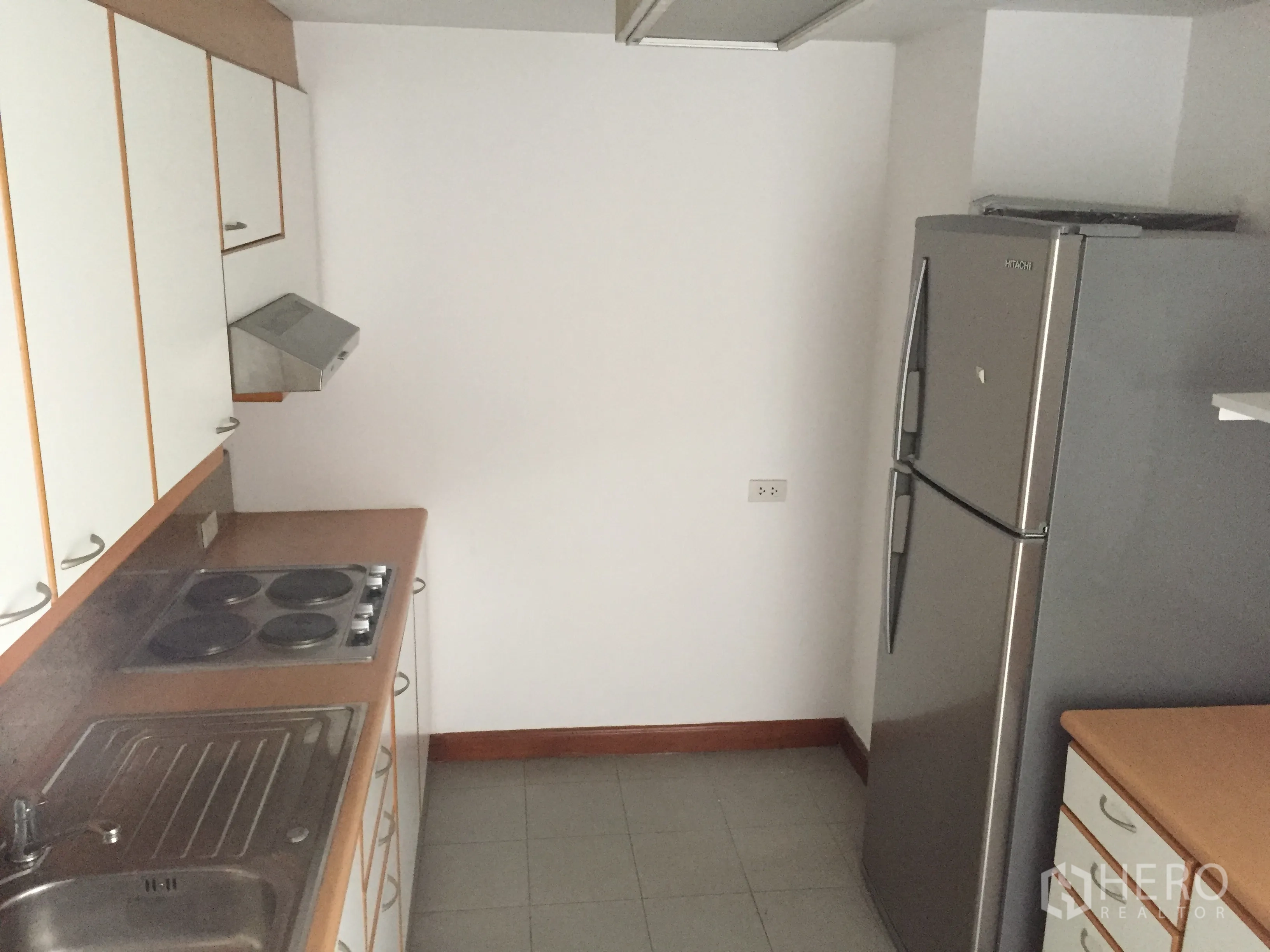 คอนโด ให้เช่าในPathum Wan, Bangkok - ครัวปิด ตู้เก็บของสีขาว เตาไฟฟ้า เครื่องดูดควัน อ่างล้างจาน และตู้เย็นสแตนเลส