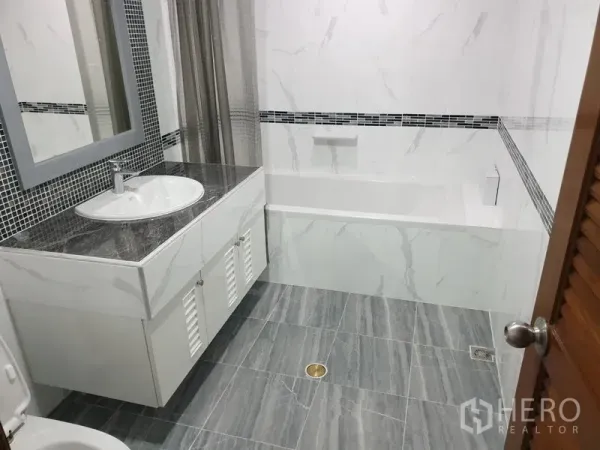 คอนโด ให้เช่าในWatthana, Bangkok - ห้องน้ำโทนหินอ่อนพร้อมเคาน์เตอร์อ่างล้างหน้าและอ่างอาบน้ำพร้อมผ้าม่าน