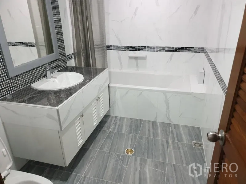 คอนโด ให้เช่าในWatthana, Bangkok - ห้องน้ำโทนหินอ่อนพร้อมเคาน์เตอร์อ่างล้างหน้าและอ่างอาบน้ำพร้อมผ้าม่าน