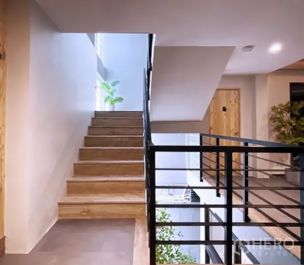 办公空间 出租在Bang Rak, Bangkok - 现代办公楼的楼梯间，木质台阶与黑色金属扶手