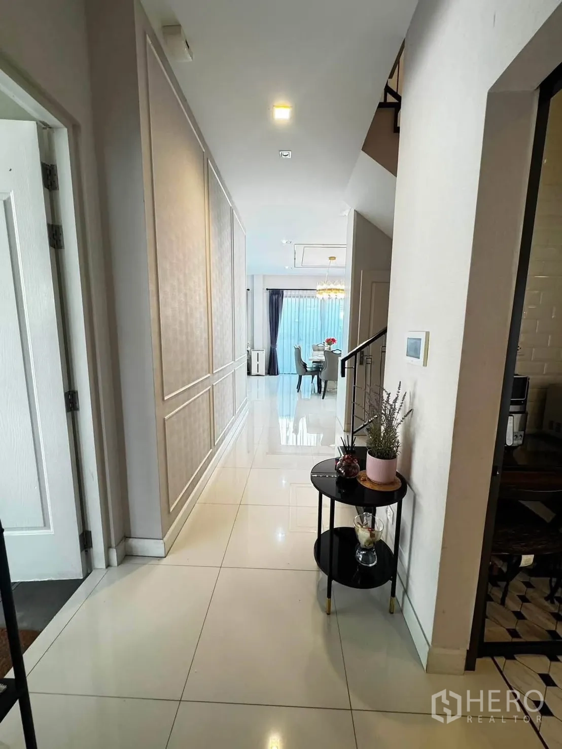 独栋房屋 for rent in Saphan Sung, Bangkok - 一层走廊铺亮面地砖，通往餐区与楼梯。