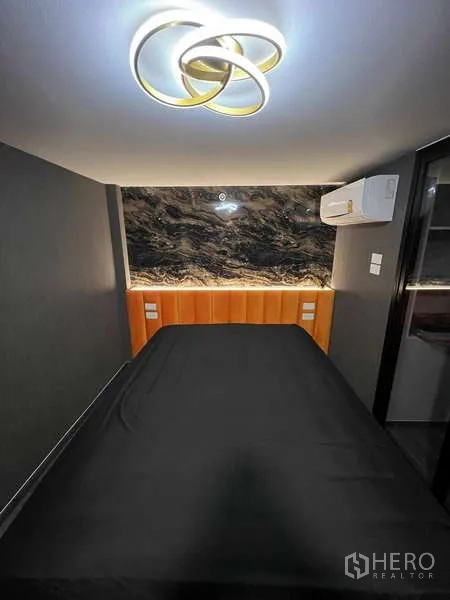 คอนโด ขายในChatuchak, Bangkok - ห้องนอนชั้นลอย โคมไฟเพดานสมัยใหม่ ผนังหัวเตียงลายหินอ่อน และเครื่องปรับอากาศ