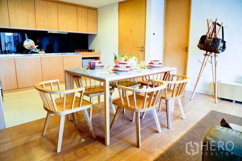 คอนโด ให้เช่าในWatthana, Bangkok - พื้นที่รับประทานอาหารแบบเปิด โต๊ะหินอ่อน เก้าอี้ไม้ และตู้ครัวลายไม้โทนอุ่น