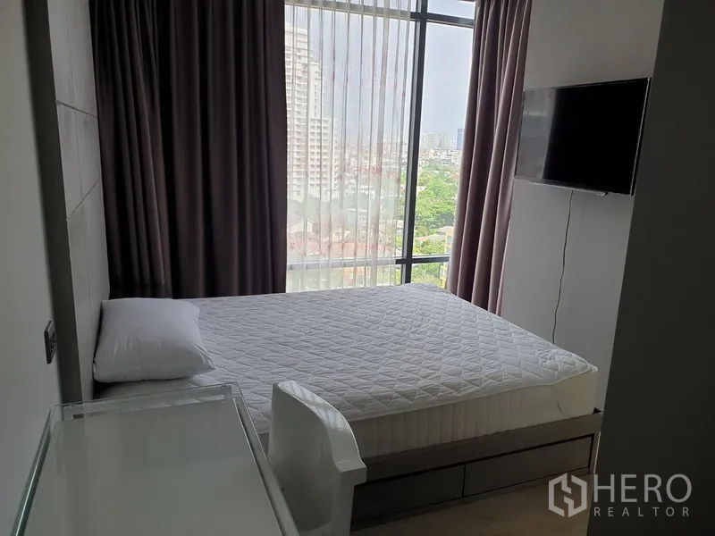 คอนโด ให้เช่าในWatthana, Bangkok - ห้องนอนหลักมีเตียง ทีวีติดผนัง กระจกเต็มบาน พร้อมวิวสกายไลน์เมือง