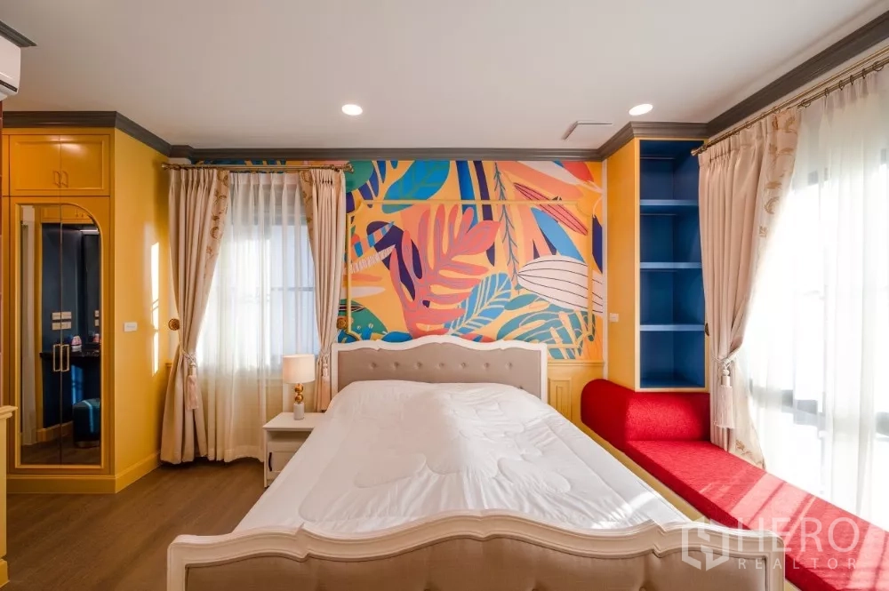 Detached House for rent or sale in Khlong Toei, Bangkok - Colorful bedroom with tropical leaf mural, bay windows and built-in storage.