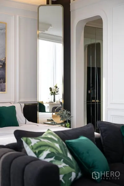 公寓 出租在Bang Rak, Bangkok - 细节特写：高挑立镜、白色墙板与绿色靠枕。