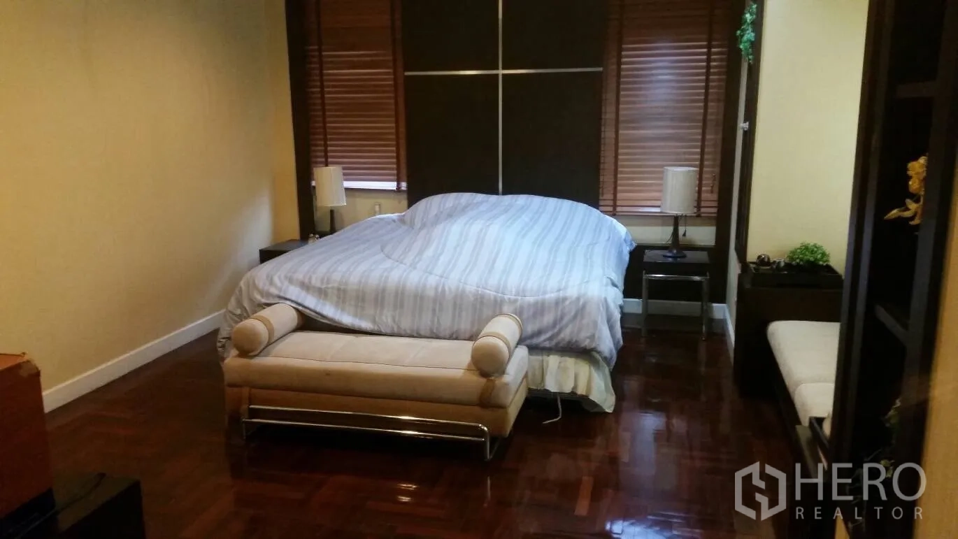 บ้าน ให้เช่าในLat Krabang, Bangkok - ห้องนอนใหญ่ เตียงขนาดกว้าง พร้อมเบาะปลายเตียงและพื้นไม้เงางาม