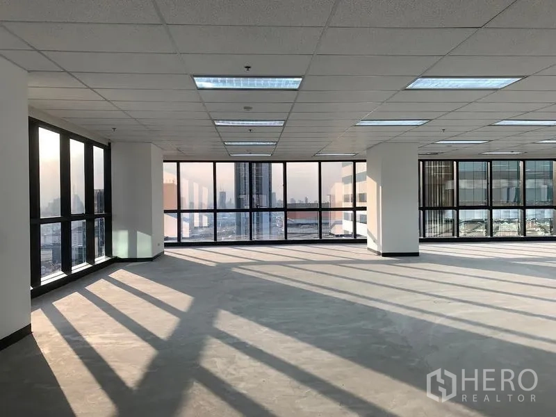 สำนักงาน ให้เช่าในDin Daeng, Bangkok - พื้นที่สำนักงานเปิดโล่ง แสงธรรมชาติ หน้าต่างสูงจรดเพดาน เพดานกริด และวิวสกายไลน์กรุงเทพฯ