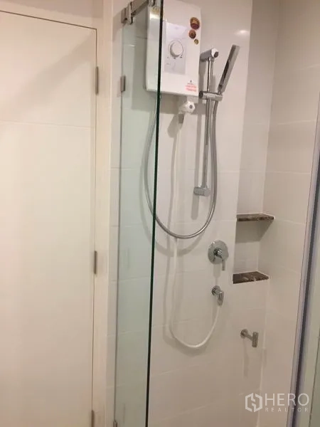 Detached House for rent in Bang Kapi, Bangkok - Glass-enclosed shower with electric water heater and wall shelves.