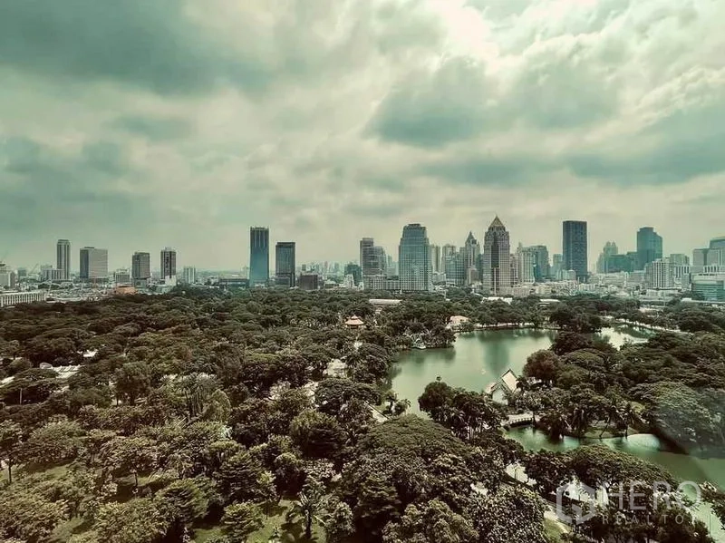 คอนโด ขายในPathum Wan, Bangkok - มุมสูงสวนลุมพินีพร้อมทะเลสาบและเส้นขอบฟ้ากรุงเทพฯ ใต้ท้องฟ้ามีเมฆ