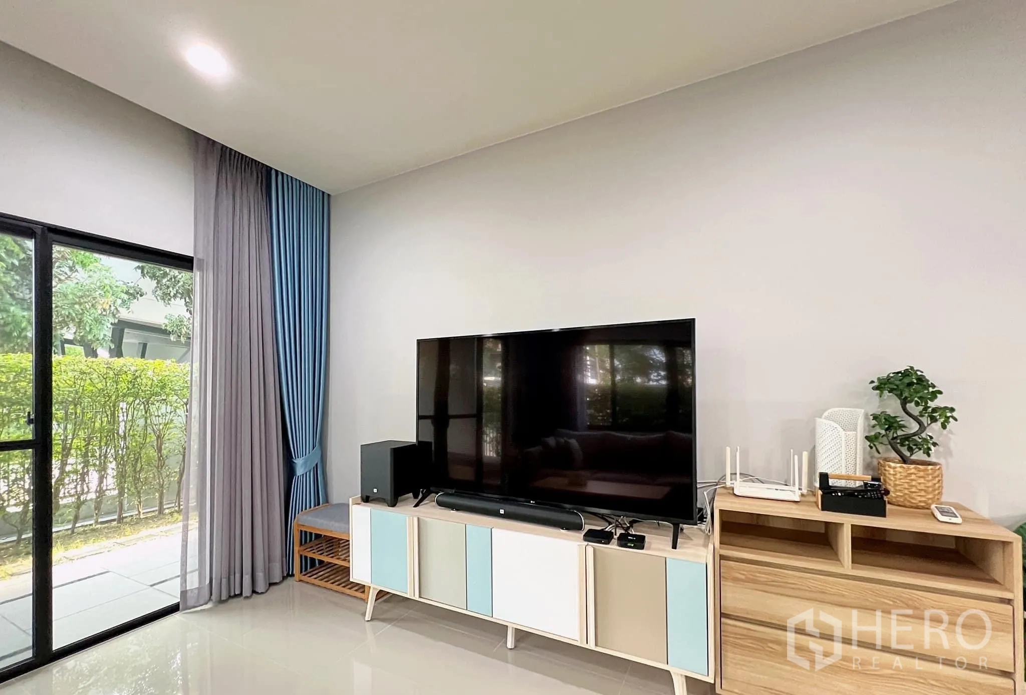 บ้าน ให้เช่าหรือขายในLam Luk Ka, Pathum Thani - ผนังทีวีพร้อมจอแบนขนาดใหญ่ ตู้วาง และประตูกระจกออกลานนั่งเล่น