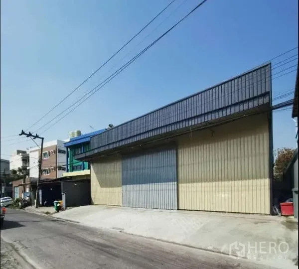 货栈 出租在Prawet, Bangkok - 临街仓库外立面，宽幅金属滑门与装卸坡道。